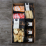 Eine wunderbare Apéro-Geschenkbox mit feinen Apéro Knusperli, Apéro Stäckli, balsamico Champignons, Apfel Chutney, würzige Tomate, Apéro Perlen salzig, Apéro Perlen scharf in einer Geschenkbox mit einer saisonalen Dekoration