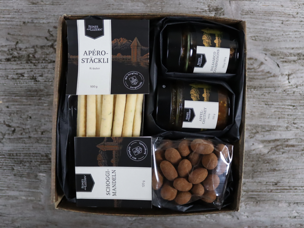 Diese Geschenk-Box kleiner Gruss ist eine schöne Art und weise jemandem zu sagen "Ich denke an dich & lasse einen Gruss da". Die feinen Köstlichkeiten Apero Stäckli, Balsmico Champignons, Apfelchutney, Schoggimandeln verpackt in eine Geschenkbox mit Deko könnte dafür nicht passender sein.